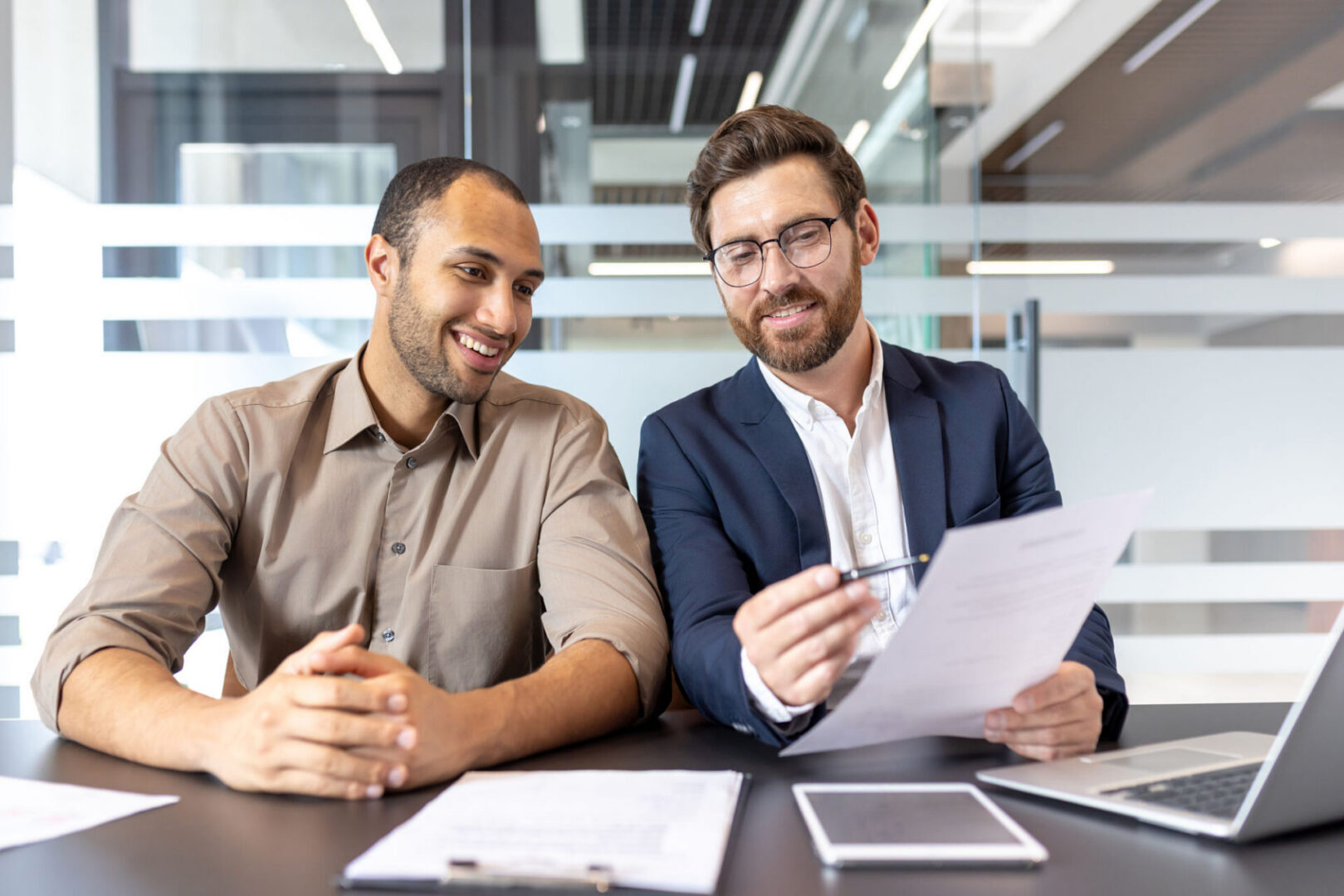 Two colleagues discussing documents at desk