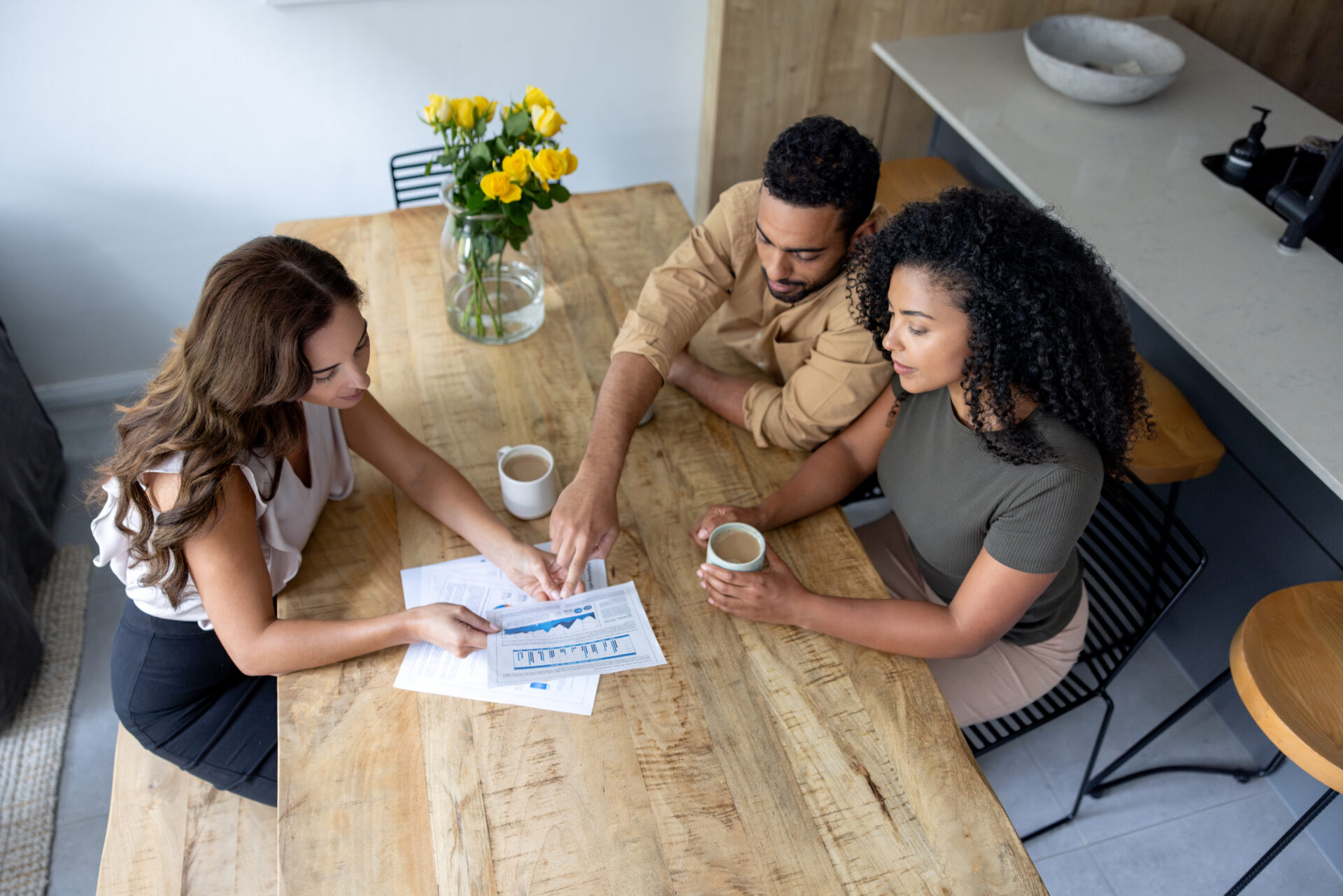 People discussing paperwork over coffee