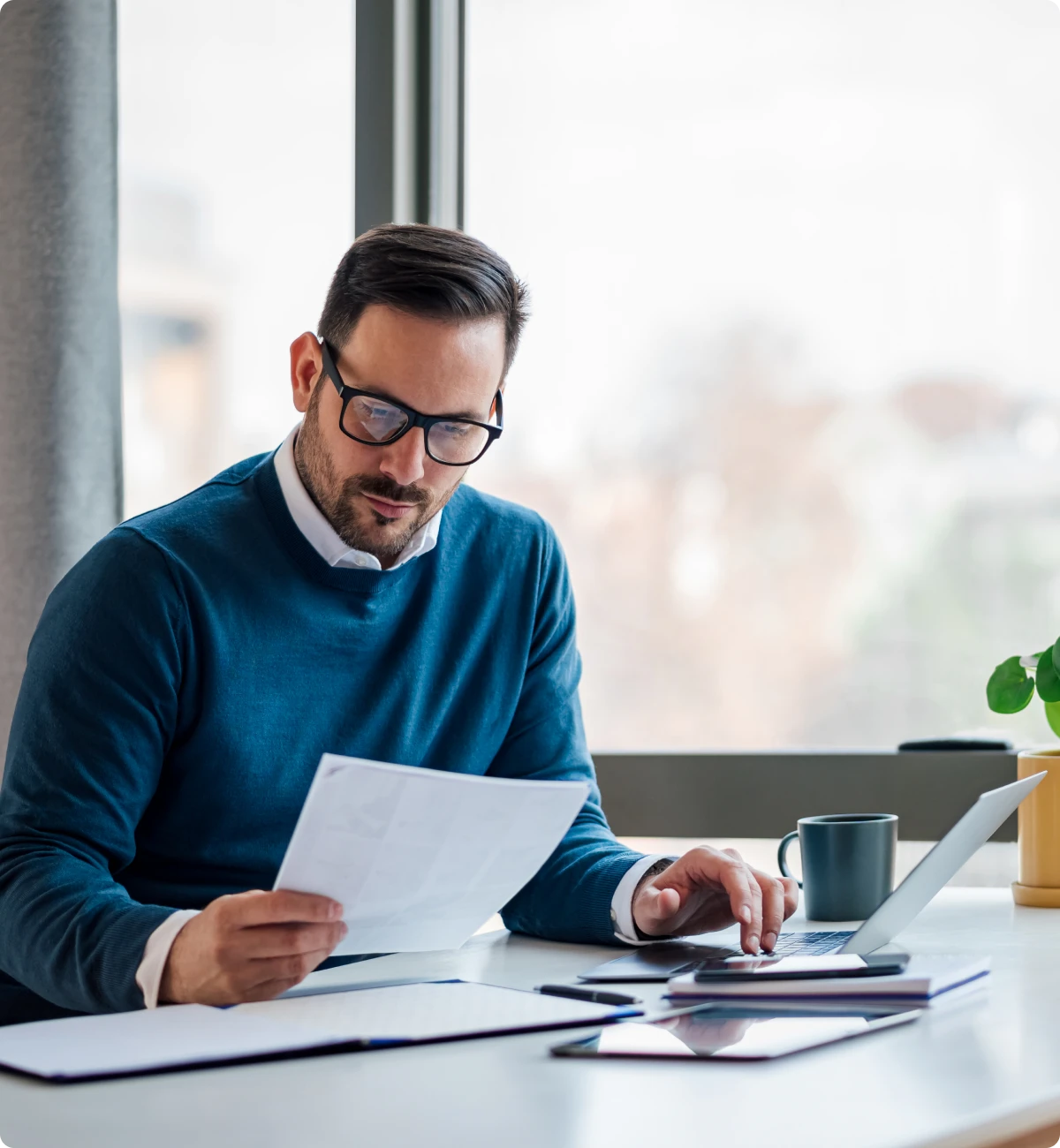 Professional working on laptop with papers